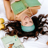 Woman with long hair happily wearing the most comfortable hand-made headband in the print Dottie on Emerald.
