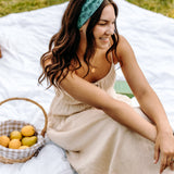 Woman with long hair happily wearing the most comfortable hand-made headband in the print Opal Floral.