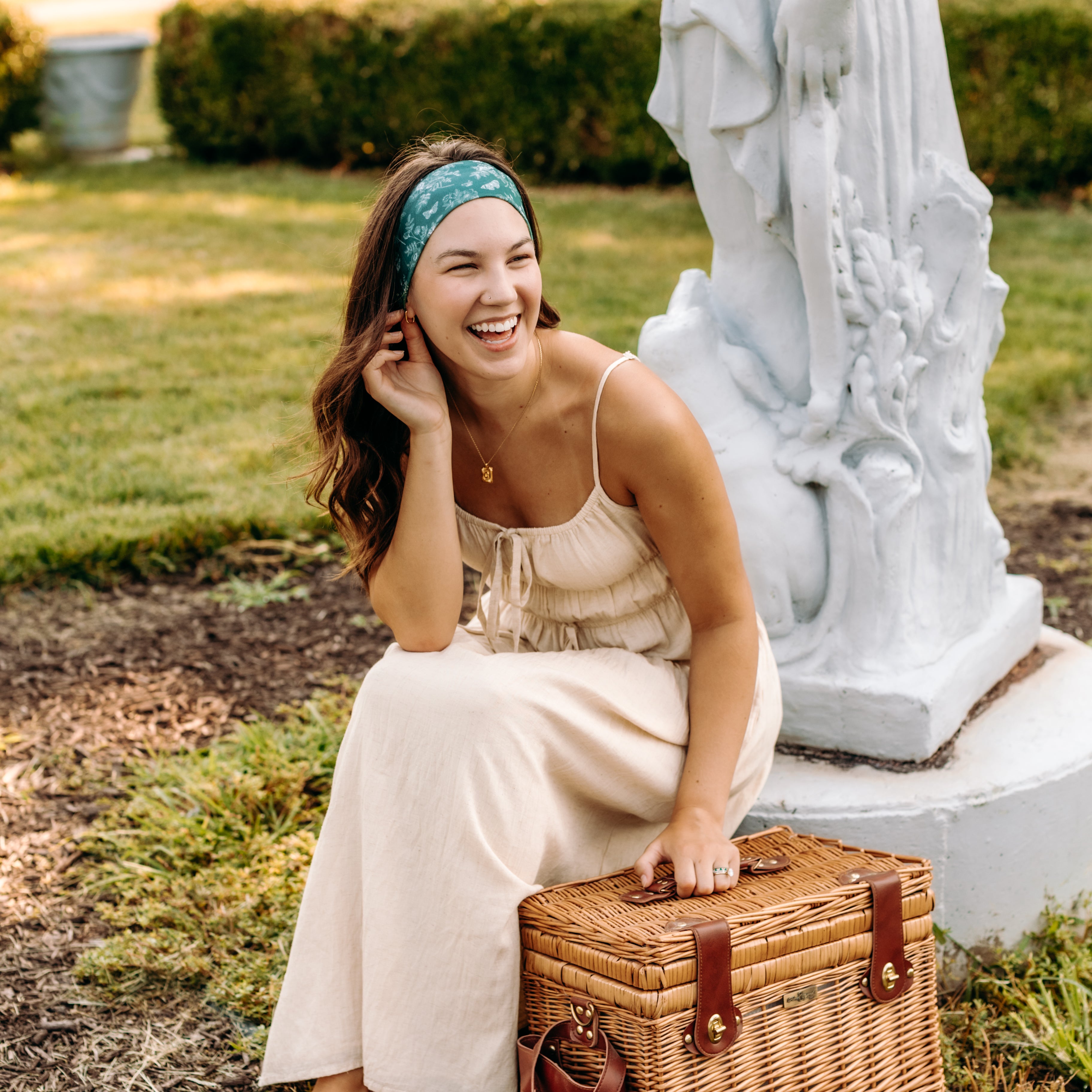 Woman with long hair happily wearing the most comfortable hand-made headband in the print Arwen Floral.