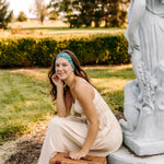 Woman with long hair happily wearing the most comfortable hand-made headband in the print Arwen Floral.