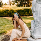 Woman with long hair happily wearing the most comfortable hand-made headband in the print Arwen Floral.