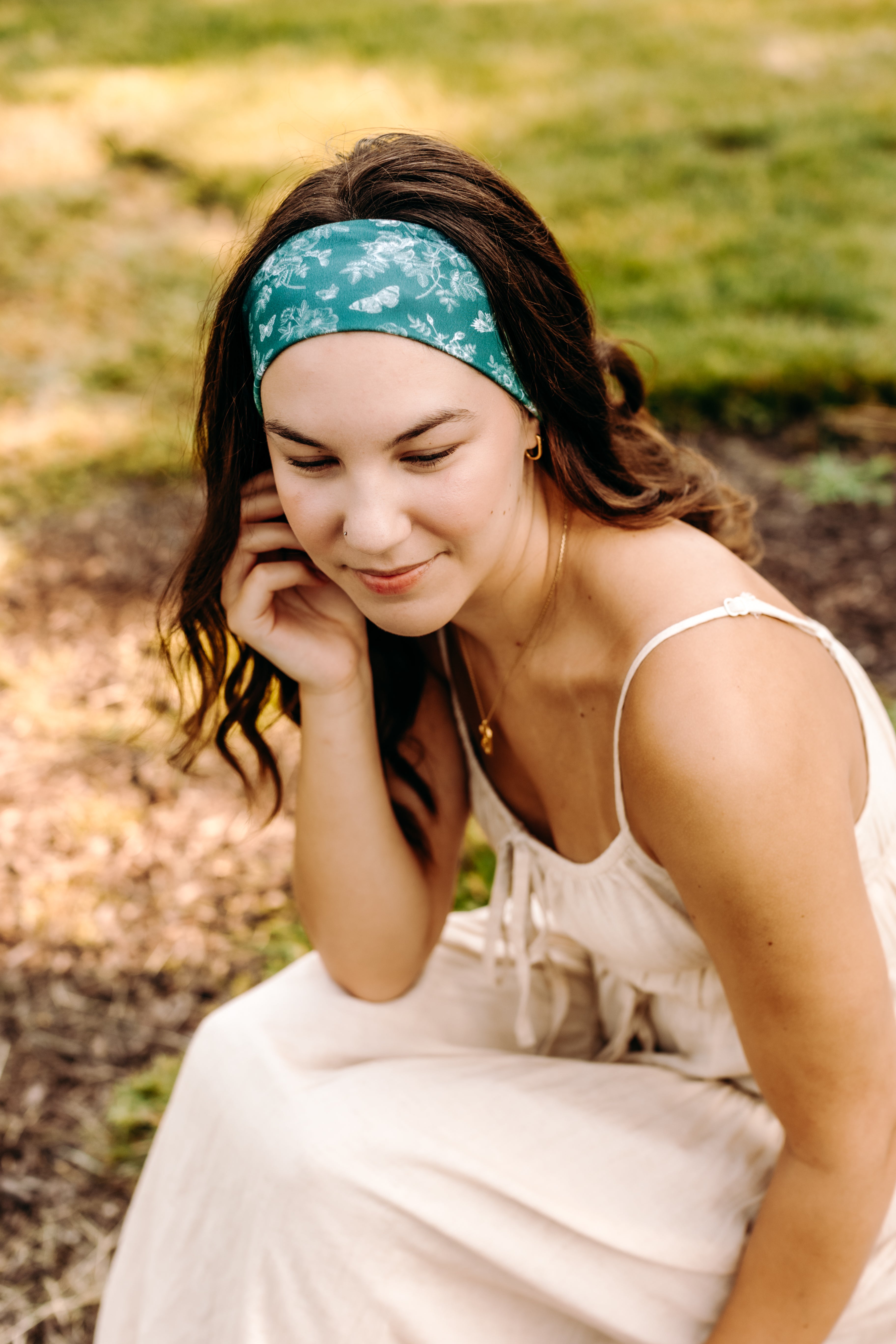 Woman with long hair happily wearing the most comfortable hand-made headband in the print Arwen Floral.
