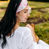Woman with long hair happily wearing the most comfortable hand-made headband in the print Catnip & Clover.