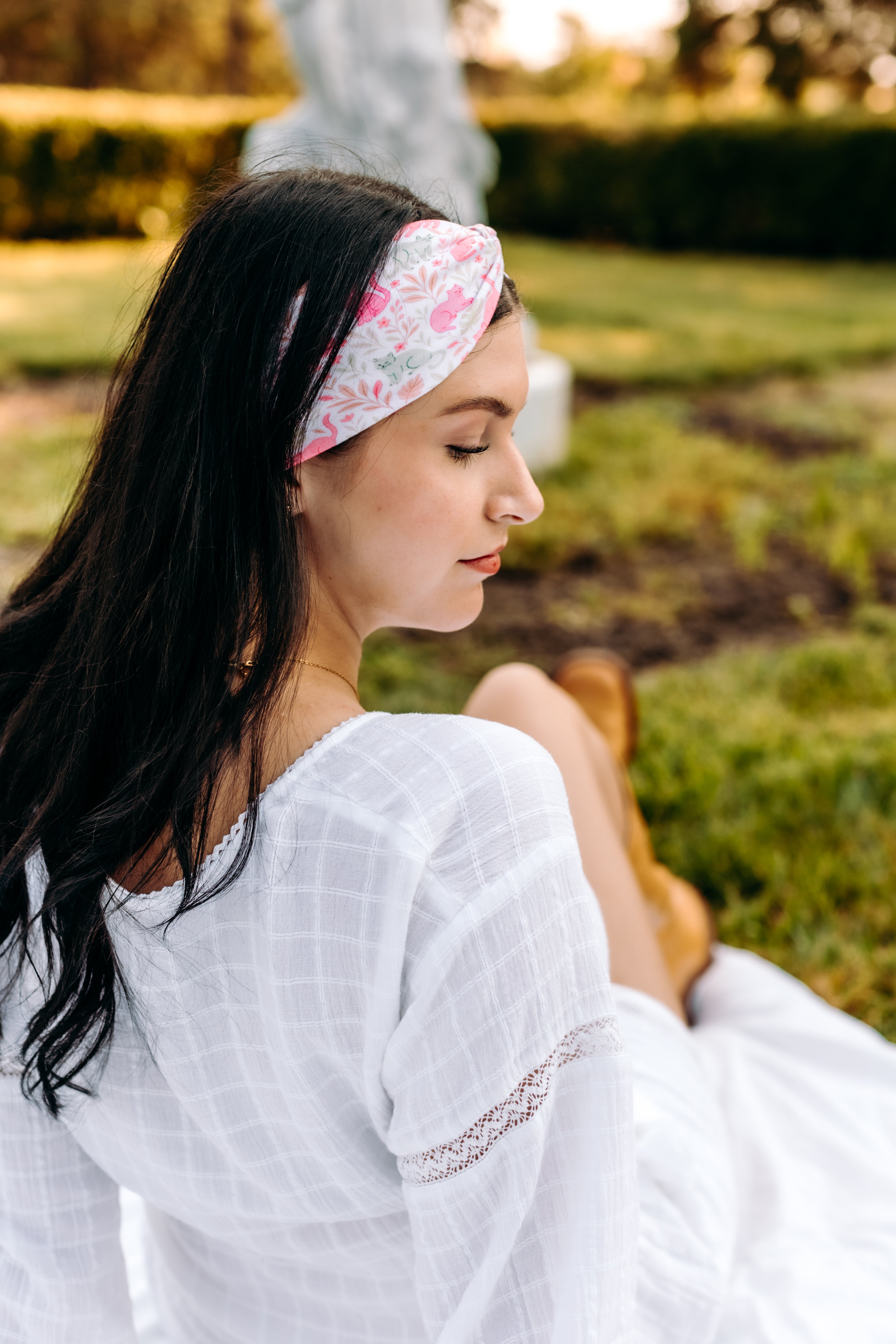 Woman with long hair happily wearing the most comfortable hand-made headband in the print Catnip & Clover.