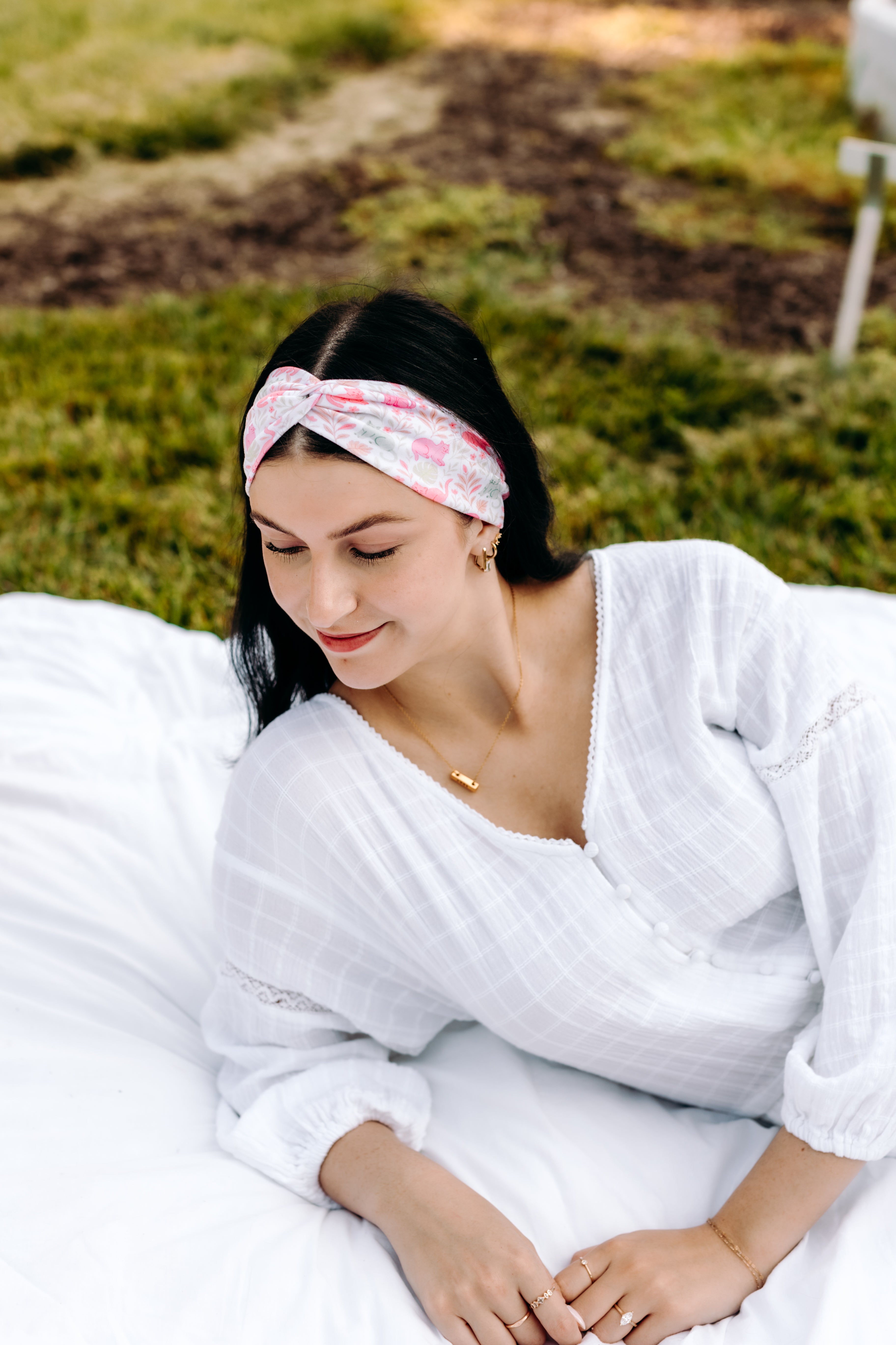 Woman with long hair happily wearing the most comfortable hand-made headband in the print Catnip & Clover.