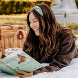 Woman with long hair happily wearing the most comfortable hand-made headband in the print Hazel Floral.