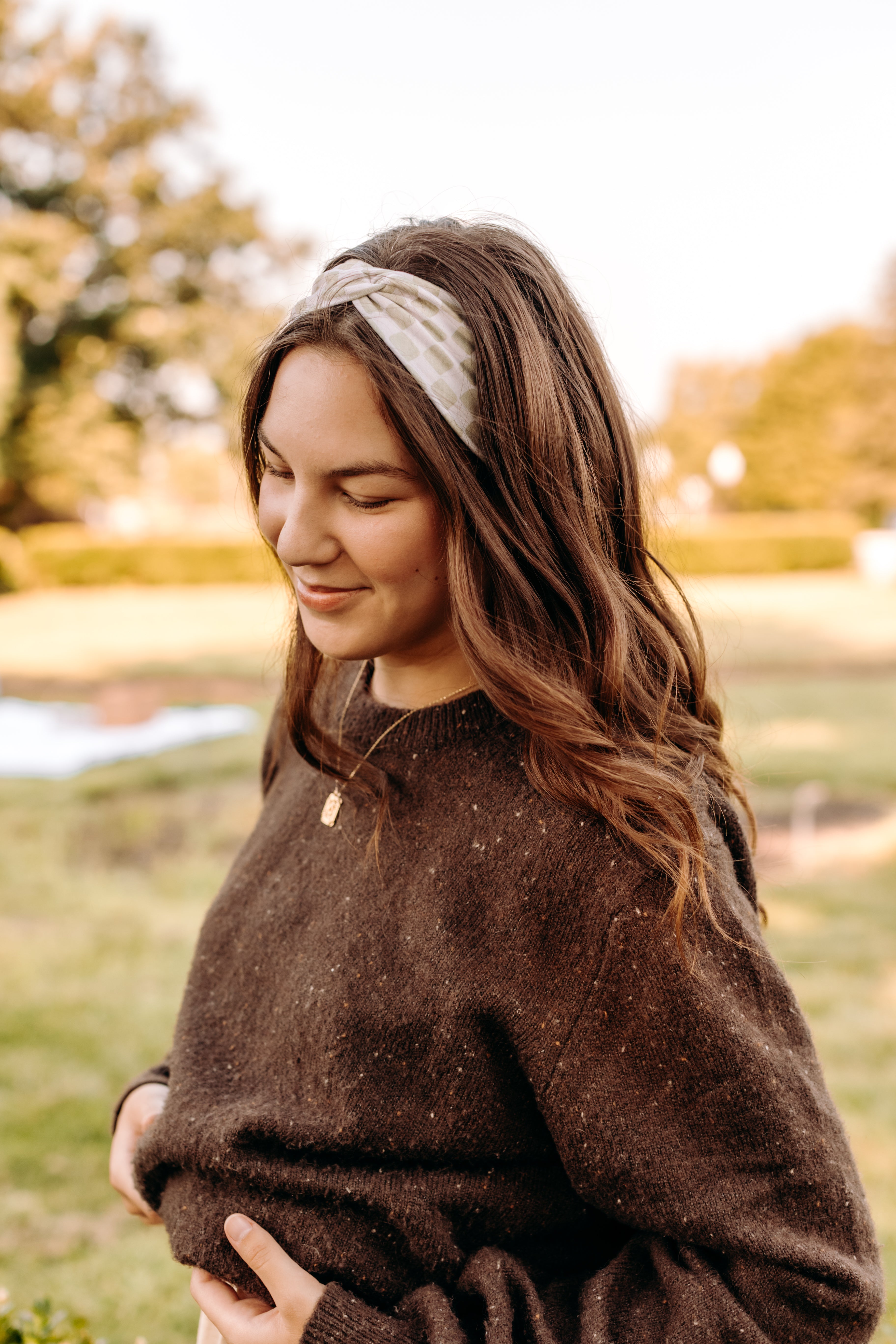 Woman with long hair happily wearing the most comfortable hand-made headband in the print Olive Patch. 
