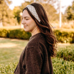 Woman with long hair happily wearing the most comfortable hand-made headband in the print Olive Patch. 