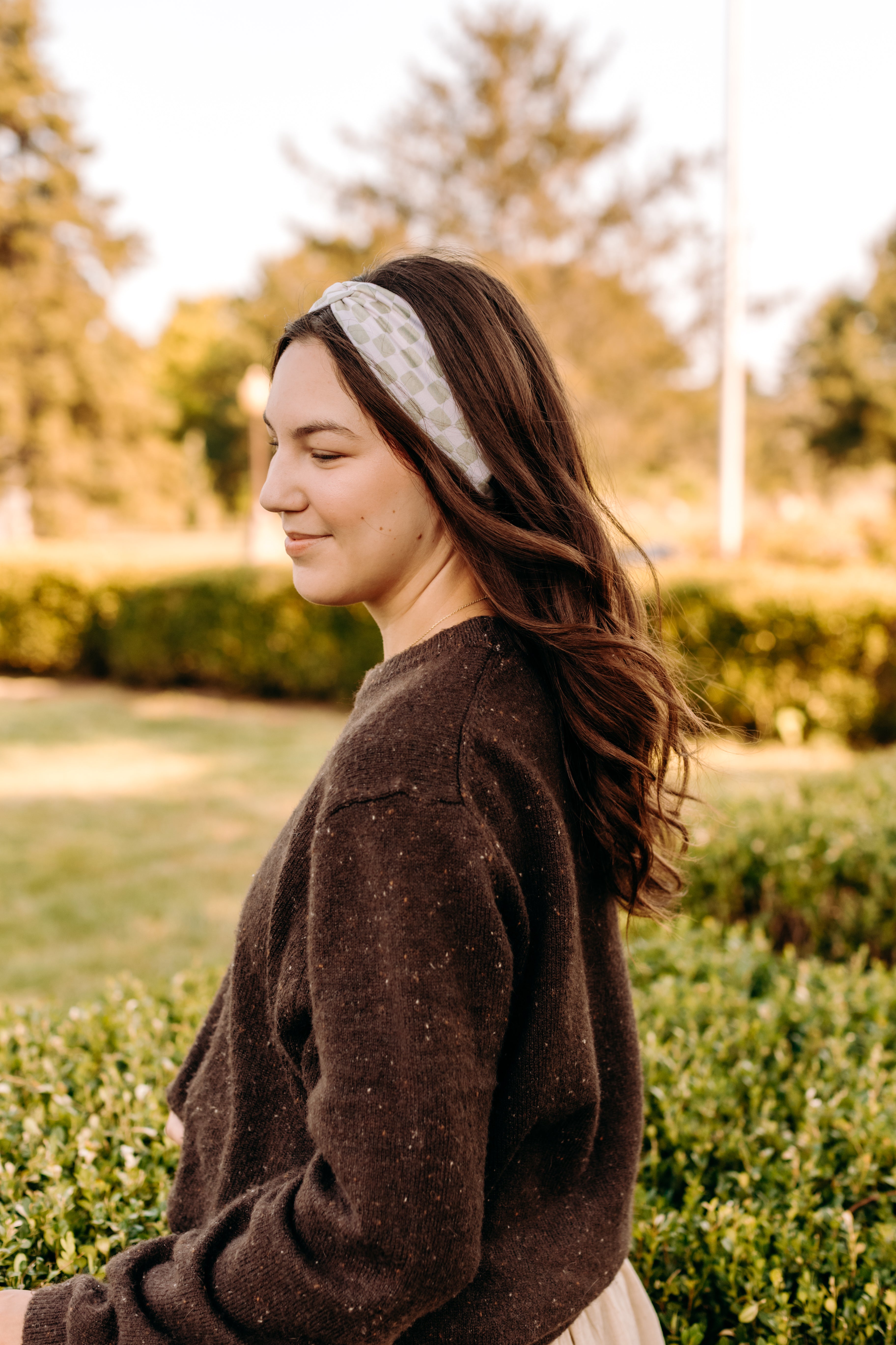Woman with long hair happily wearing the most comfortable hand-made headband in the print Olive Patch. 