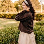 Woman with long hair happily wearing the most comfortable hand-made headband in the print Olive Patch. 