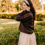 Woman with long hair happily wearing the most comfortable hand-made headband in the print Olive Patch. 