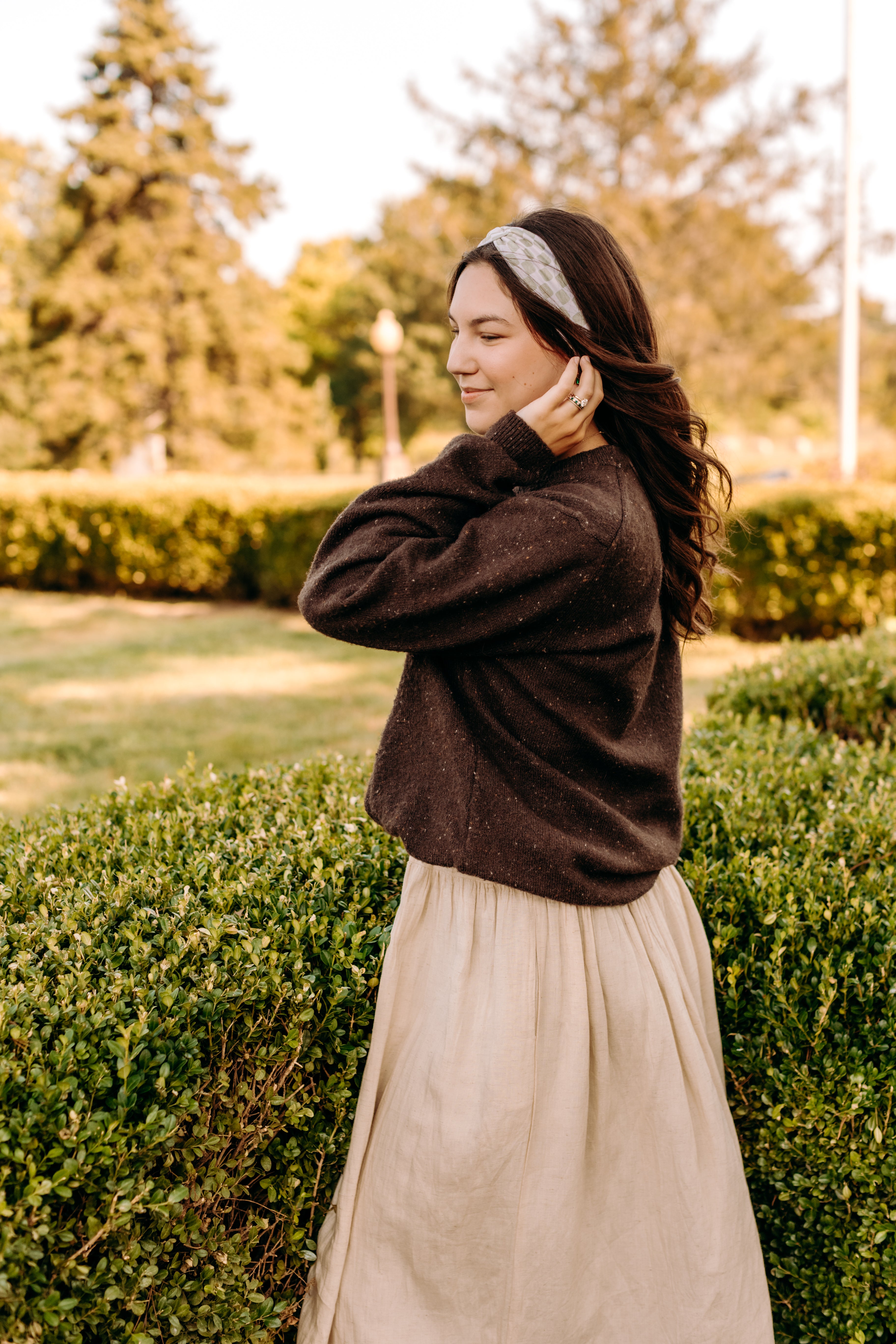 Woman with long hair happily wearing the most comfortable hand-made headband in the print Olive Patch. 
