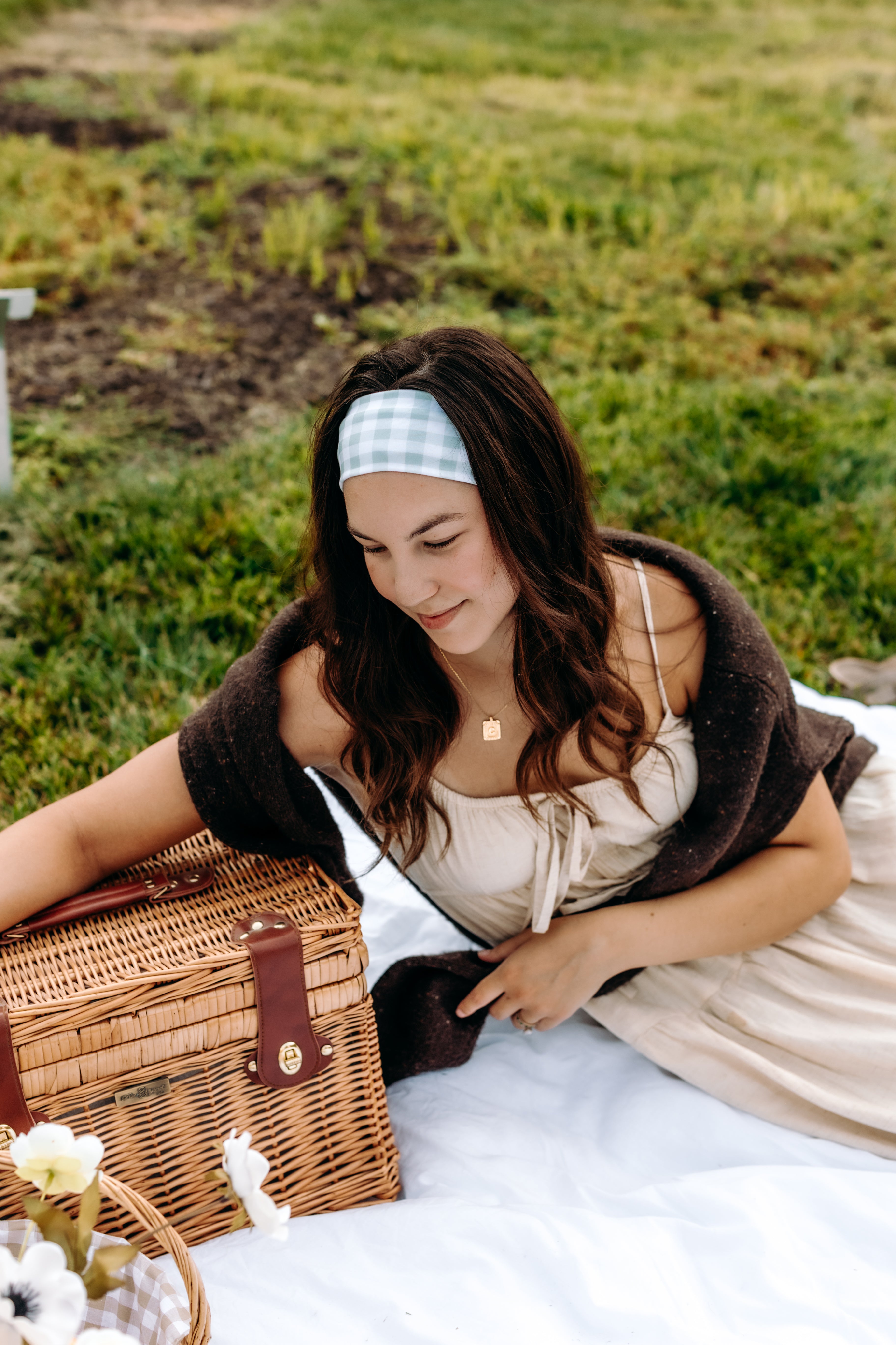 Woman with long hair happily wearing the most comfortable hand-made headband in the print Greenhouse Gingham.