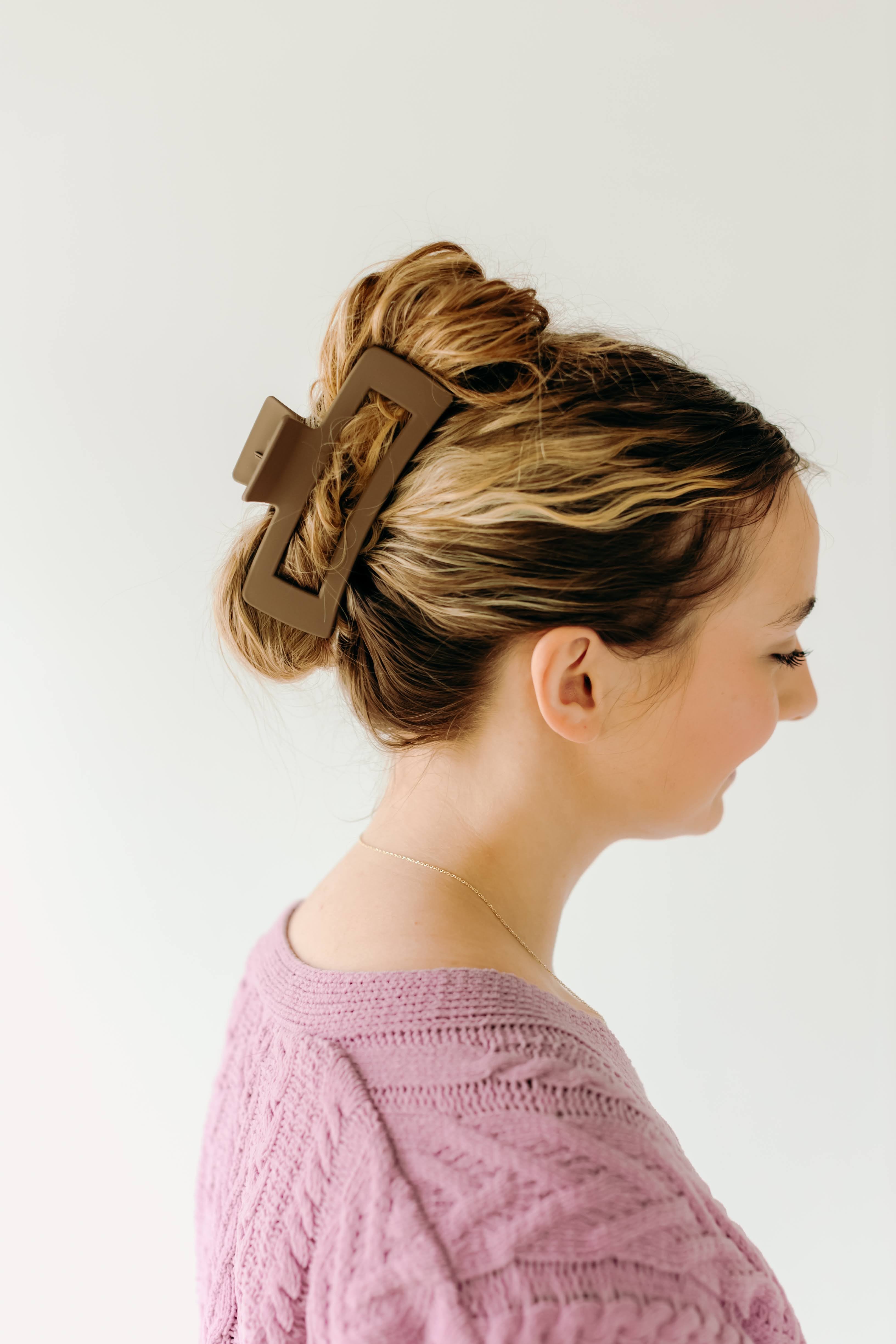 A woman wearing a mocha XL Essential Lilac Clip, a matte hair accessory with a hinge closure. 4.8 inches long, suitable for all hair types.