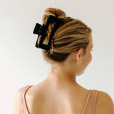 A woman wearing a black XL Essential Lilac Clip, a matte hair accessory with a hinge closure. 4.8 inches long, suitable for all hair types.