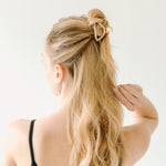 A women with long hair confidently wearing an Endless Weekend Lilac Clip, a glossy metal hair accessory with a hinge closure. Perfect for all hair types.