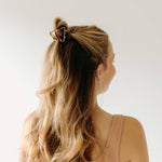 A women with long hair confidently wearing an Endless Weekend Lilac Clip, a glossy metal hair accessory with a hinge closure. Perfect for all hair types.