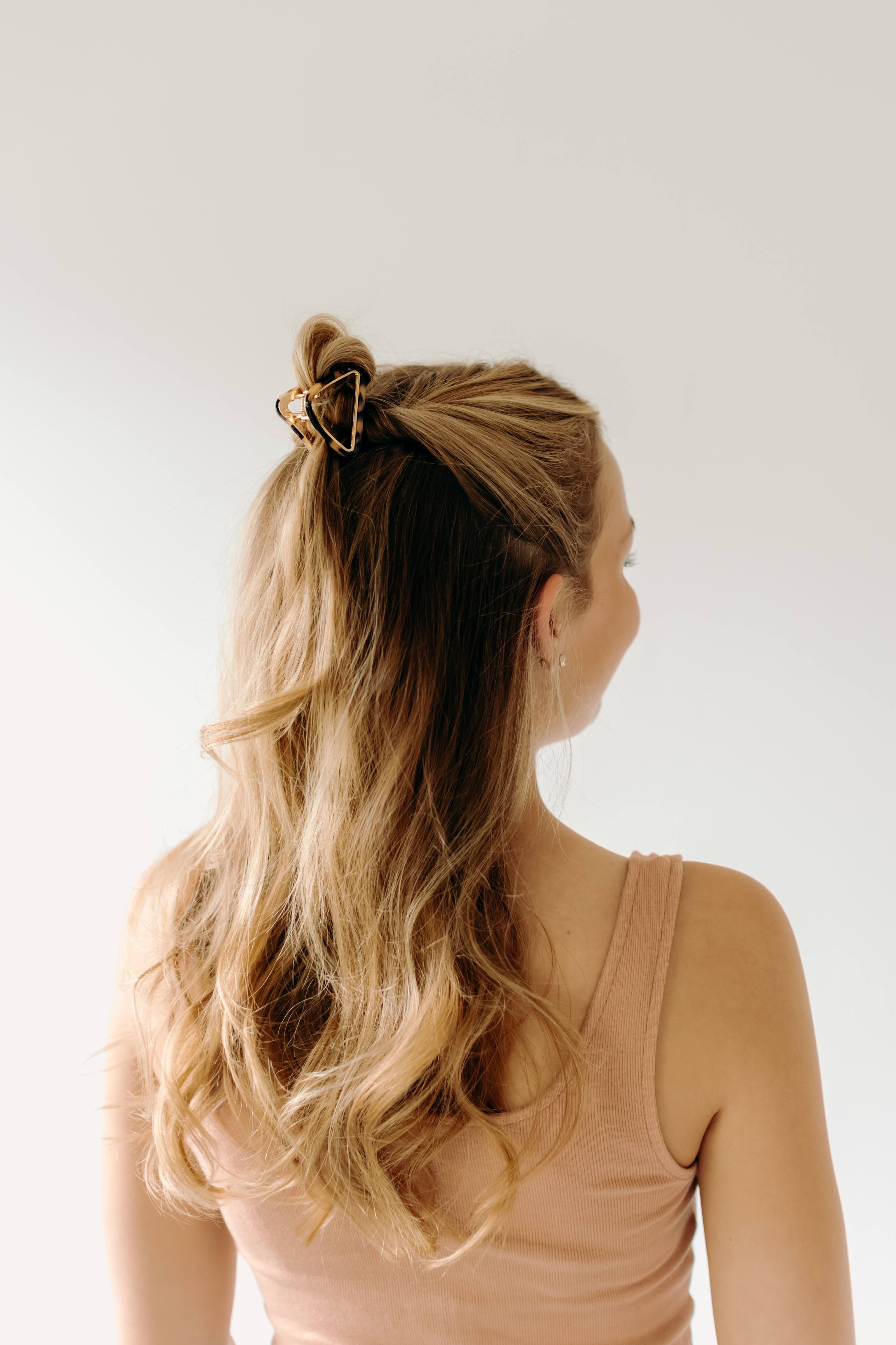 A women with long hair confidently wearing an Endless Weekend Lilac Clip, a glossy metal hair accessory with a hinge closure. Perfect for all hair types.