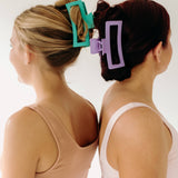 Two women wearing Vacation Vibes Lilac Clips with stylish hair, a fashion accessory perfect for all hair types. Matte material, 4.8 inches long, with a hinge closure.