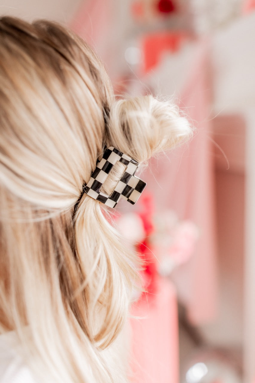Checking In Lilac Clip: a 2-inch glossy checkered claw clip with a hinge closure, perfect for styling and keeping hair in place.