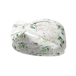 A Springtime in Brooklyn headband, featuring a white headband with green leaf pattern, versatile 3-in-1 twist style, and ultra-stretchy poly-knit blend.