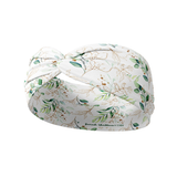 A Springtime in Brooklyn headband, featuring a white headband with green leaf pattern, versatile 3-in-1 twist style, and ultra-stretchy poly-knit blend.