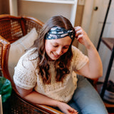 Woman confidently wearing the Lines, Vines & Felines headband for cute hairstyles and comfortable all-day wear.