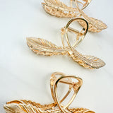 One of a Kind Lilac Clip from The Sarah Wallace collection: Gold hair clip with feather design, 4.4 inches long, hinge closure, ideal for keeping hair out of the face.