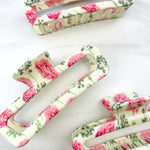 No Rain, No Flowers Clip featuring a pink peony floral design, glossy material, and hinge closure from The Sarah Wallace Collection.