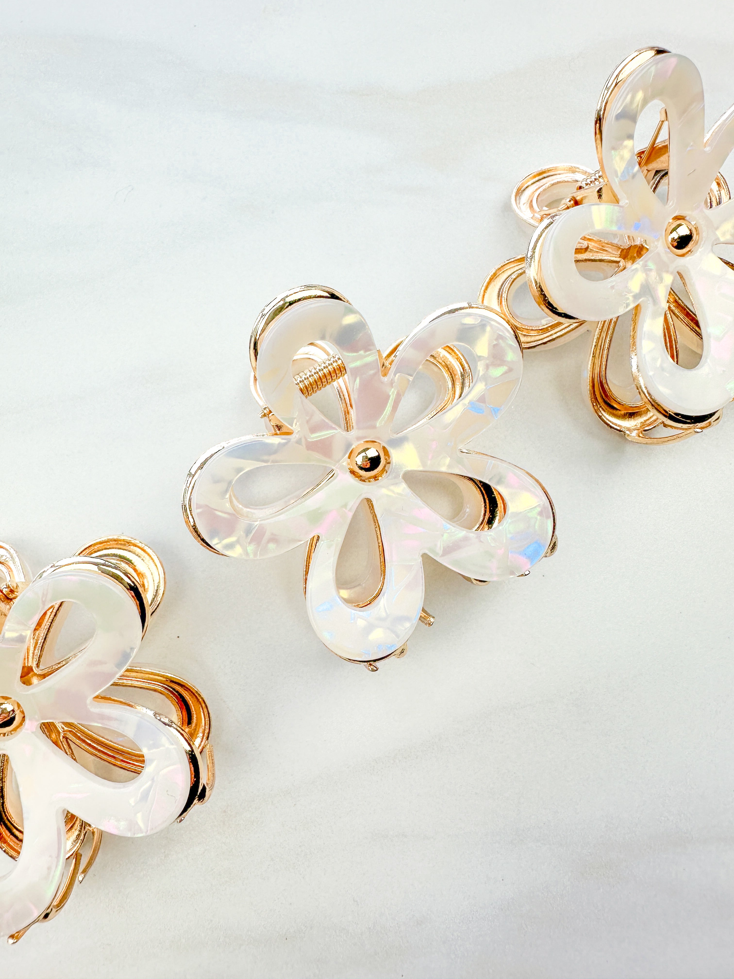 Central Park Stroll Clip: A close-up of a marble and metal hair claw clip, 2.75 inches long, featuring a hinge closure, ideal for keeping hair out of your face.