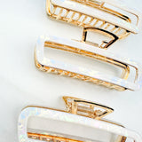 White Break A Leg Clip from The Sarah Wallace Collection, featuring a marble and metal design with a hinge closure.