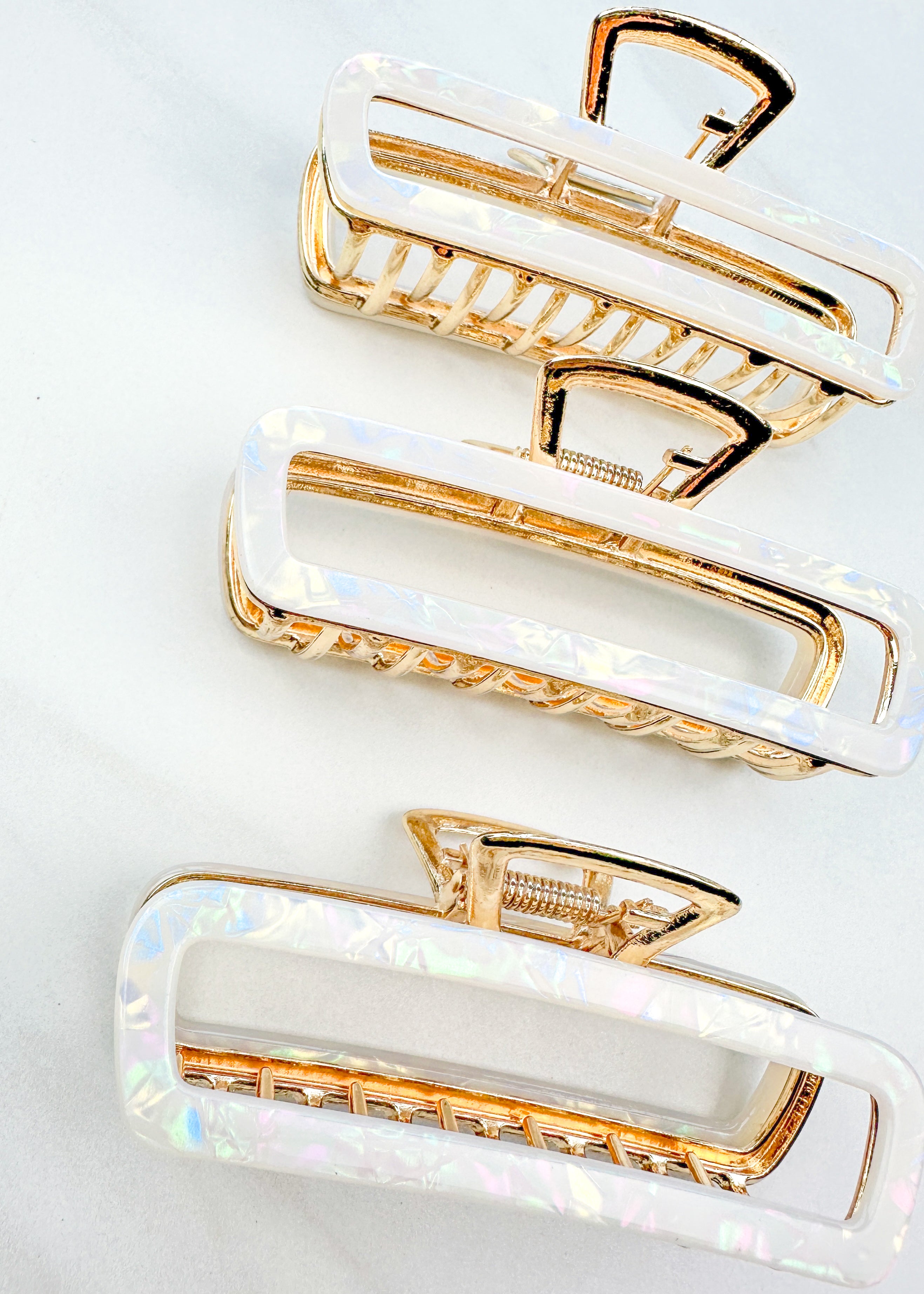 White Break A Leg Clip from The Sarah Wallace Collection, featuring a marble and metal design with a hinge closure.