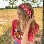 Woman smiling in a red Karma Is the Guy on the Chiefs headband, showcasing its versatile, functional design for workouts, long shifts, or playdays.