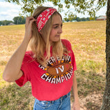 Woman smiling in a red Karma Is the Guy on the Chiefs headband, showcasing its versatile, functional design for workouts, long shifts, or playdays.