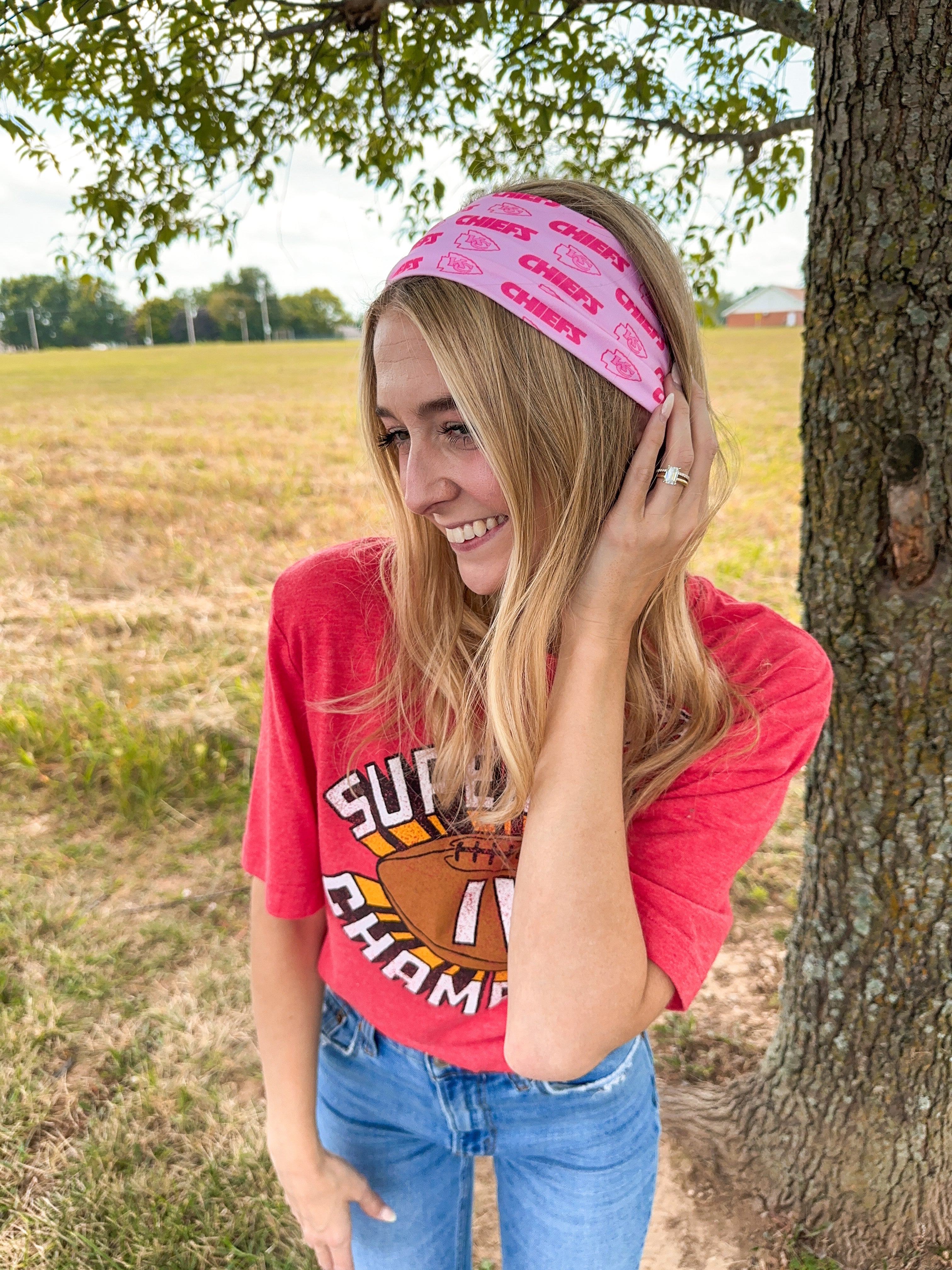 Woman confidently wearing On Sunday's We Wear Pink headband, smiling outdoors. The headband is functional, ultra-stretchy, and perfect for workouts or casual wear.