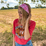 Woman confidently wearing On Sunday's We Wear Pink headband, smiling outdoors. The headband is functional, ultra-stretchy, and perfect for workouts or casual wear.