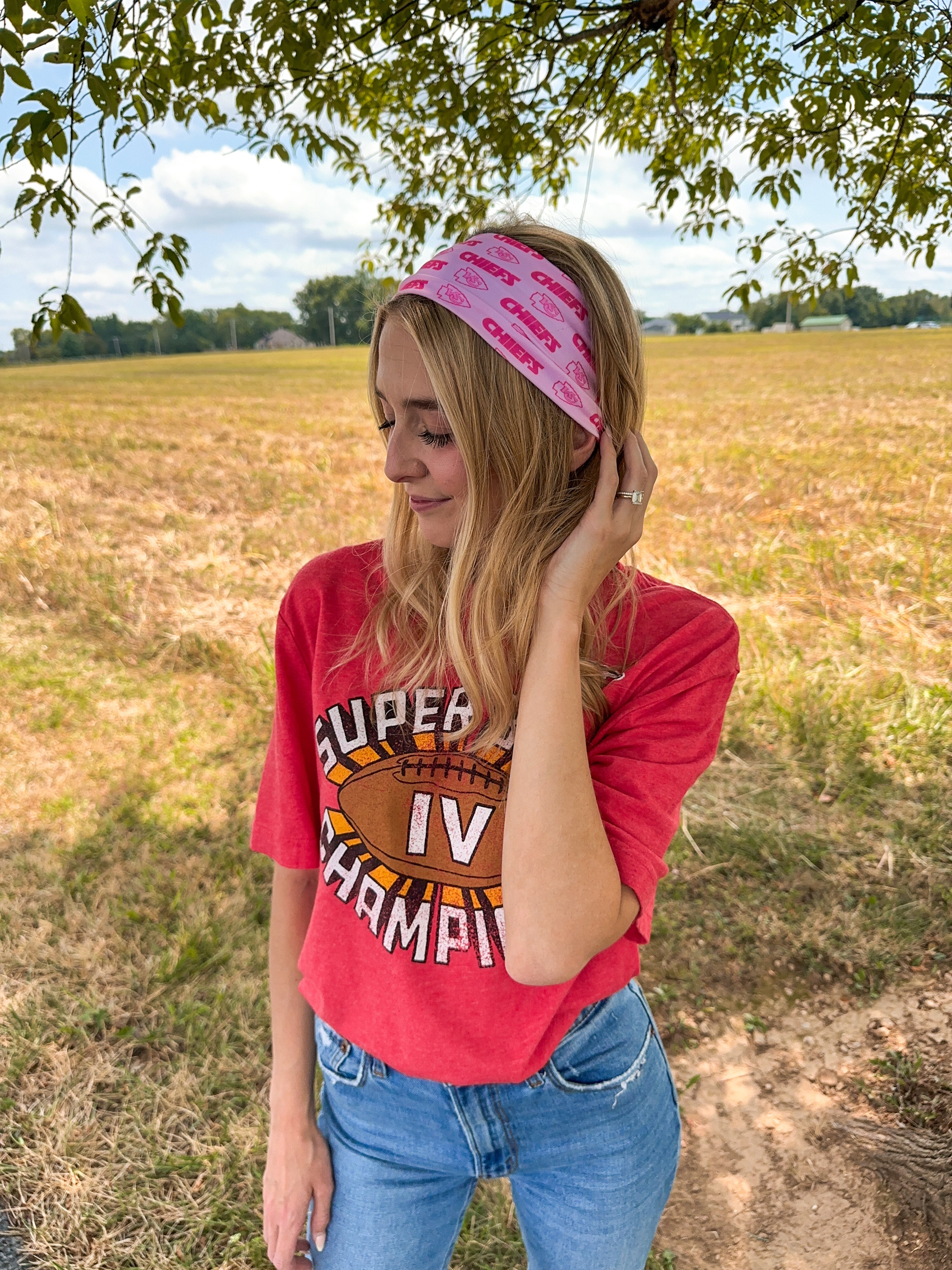 Woman confidently wearing On Sunday's We Wear Pink headband, smiling outdoors. The headband is functional, ultra-stretchy, and perfect for workouts or casual wear.