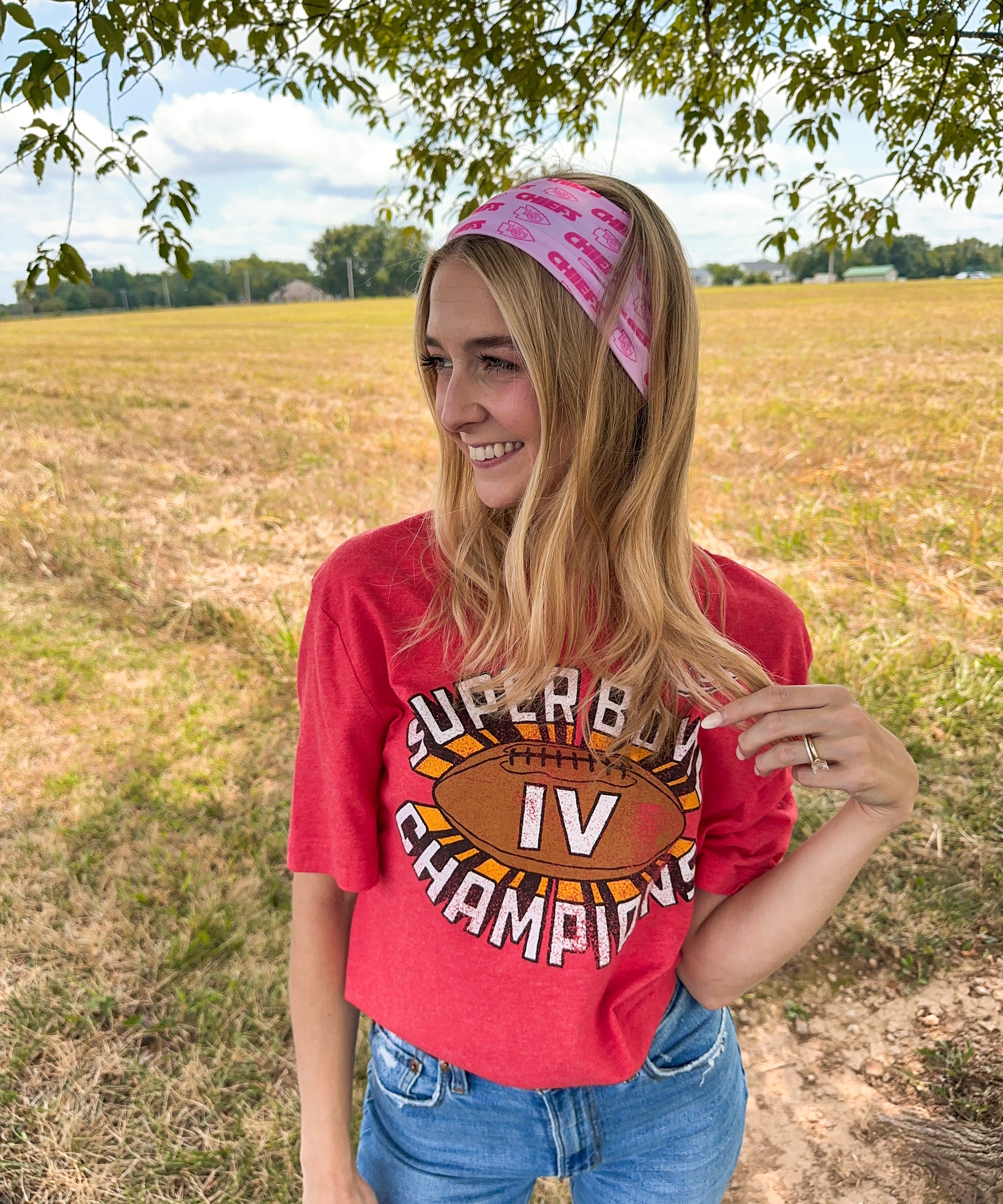 Woman confidently wearing On Sunday's We Wear Pink headband, smiling outdoors. The headband is functional, ultra-stretchy, and perfect for workouts or casual wear.
