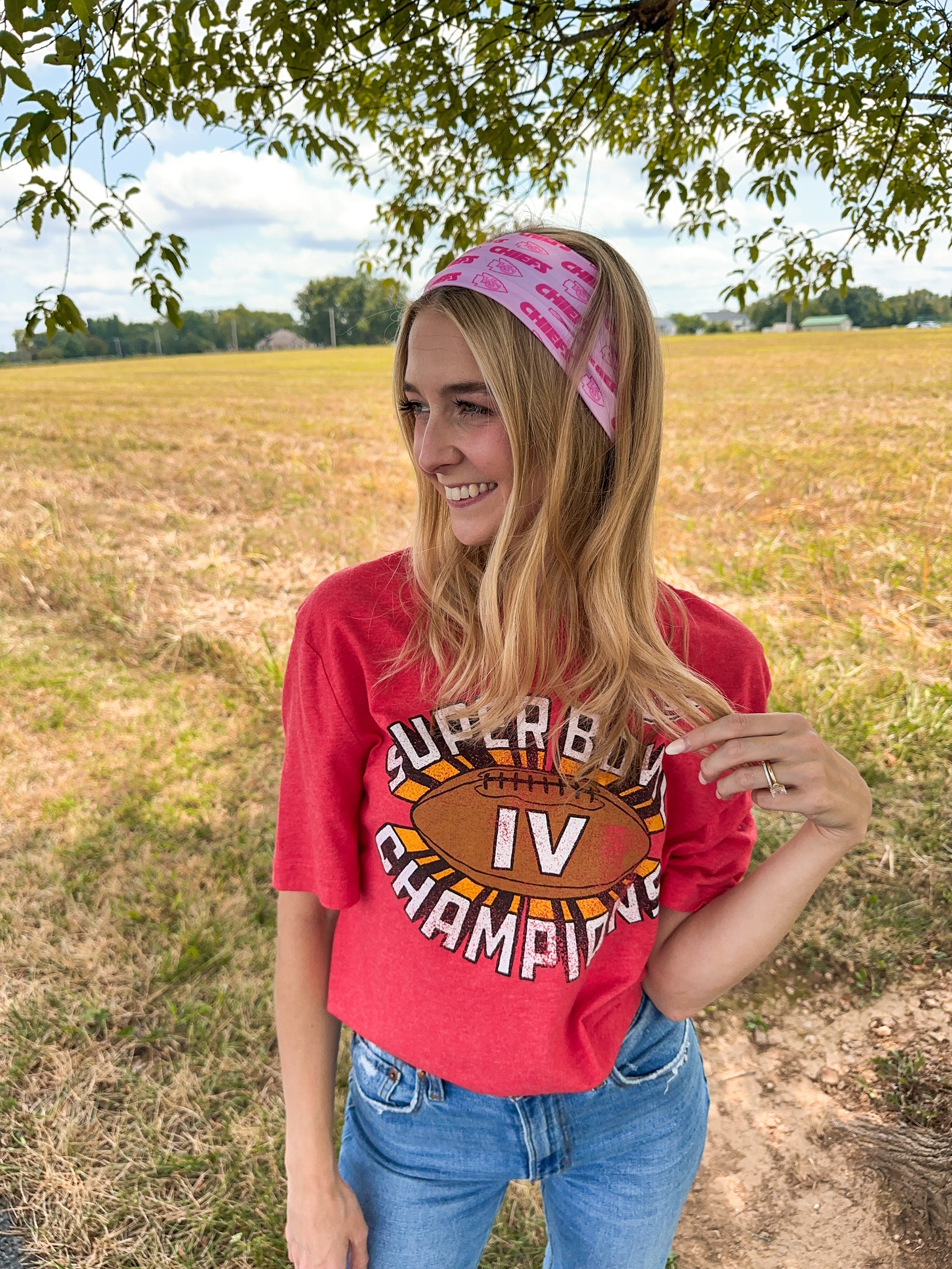 Woman confidently wearing On Sunday's We Wear Pink headband, smiling outdoors. The headband is functional, ultra-stretchy, and perfect for workouts or casual wear.