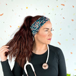 Woman wearing Beautiful Day to Catch Babies Lilac Market Headband with stethoscope, exuding confidence and style.