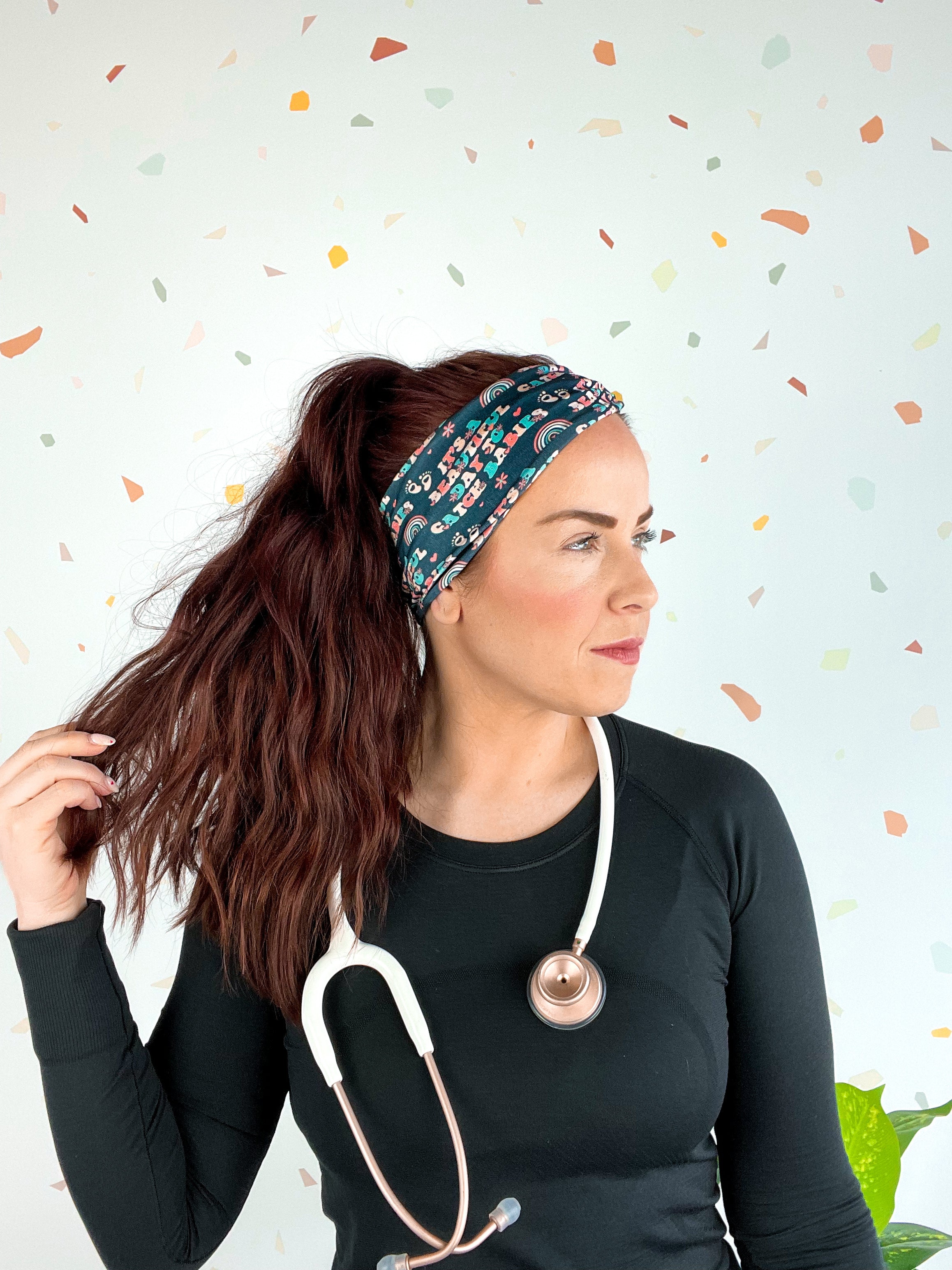 Woman wearing Beautiful Day to Catch Babies Lilac Market Headband with stethoscope, exuding confidence and style.