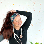 Woman wearing Beautiful Day to Catch Babies Lilac Market Headband with stethoscope, exuding confidence and style.