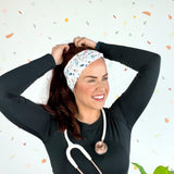 A woman wearing the Ask Me About Our Burritos headband with a stethoscope, smiling.