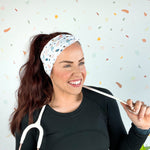 A woman wearing the Ask Me About Our Burritos headband with a stethoscope, smiling.