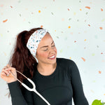 A woman wearing the Ask Me About Our Burritos headband with a stethoscope, smiling.