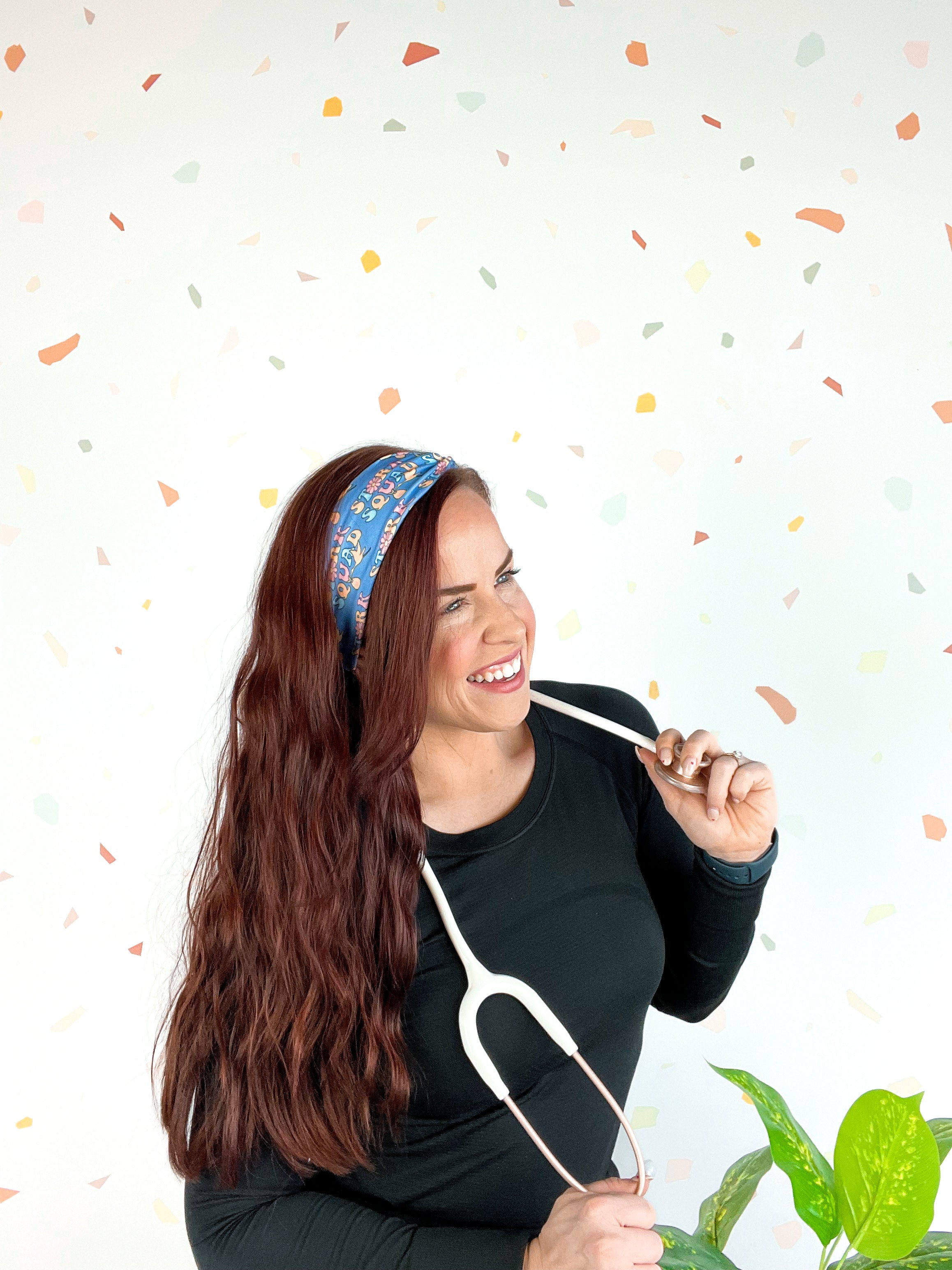 Stork Squad blue headband worn by woman with stethoscope and long hair.