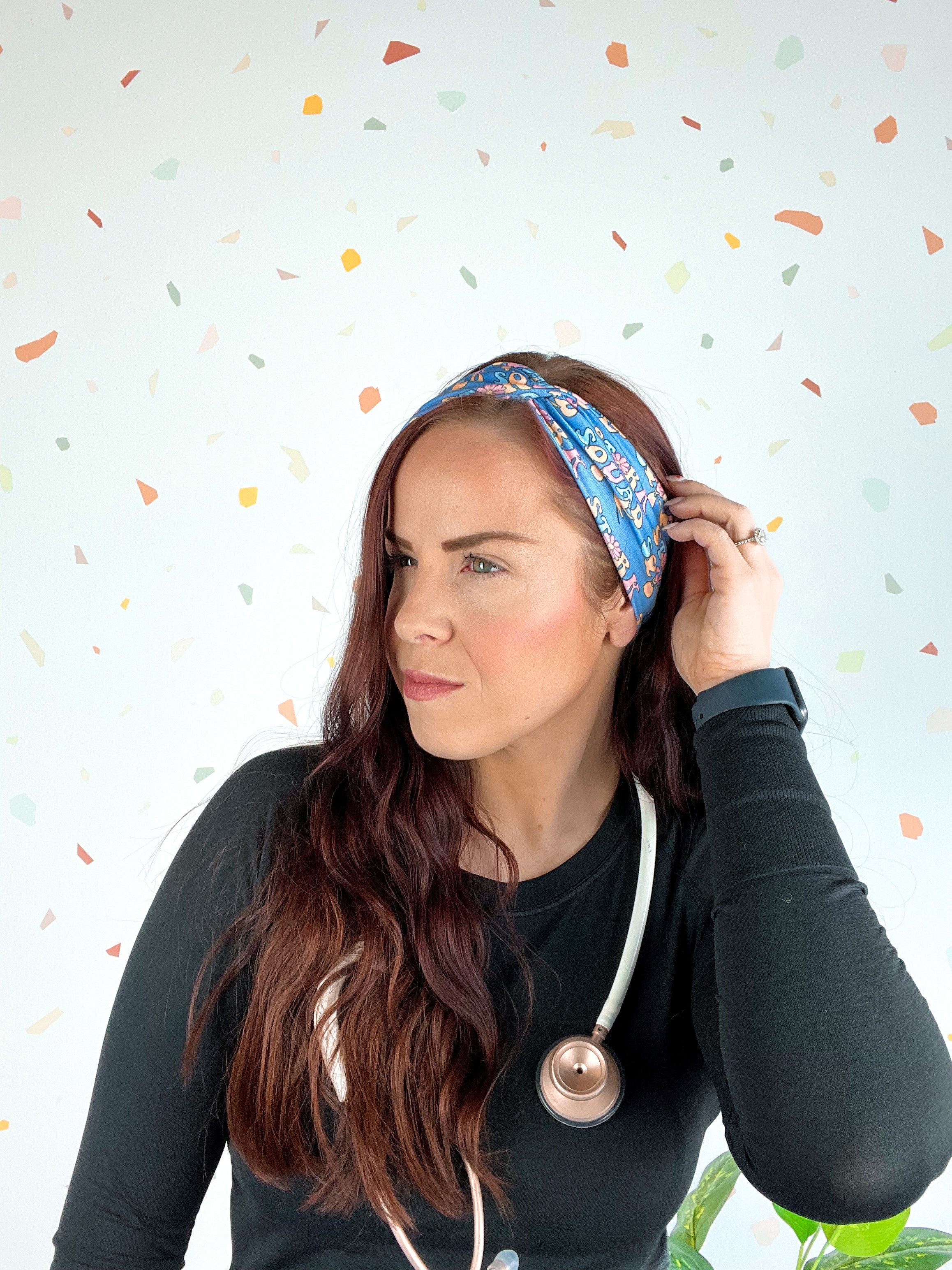 Stork Squad blue headband worn by woman with stethoscope and long hair.