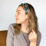 Adult women's black headband with mustard and pink flowers and green and teal greenery