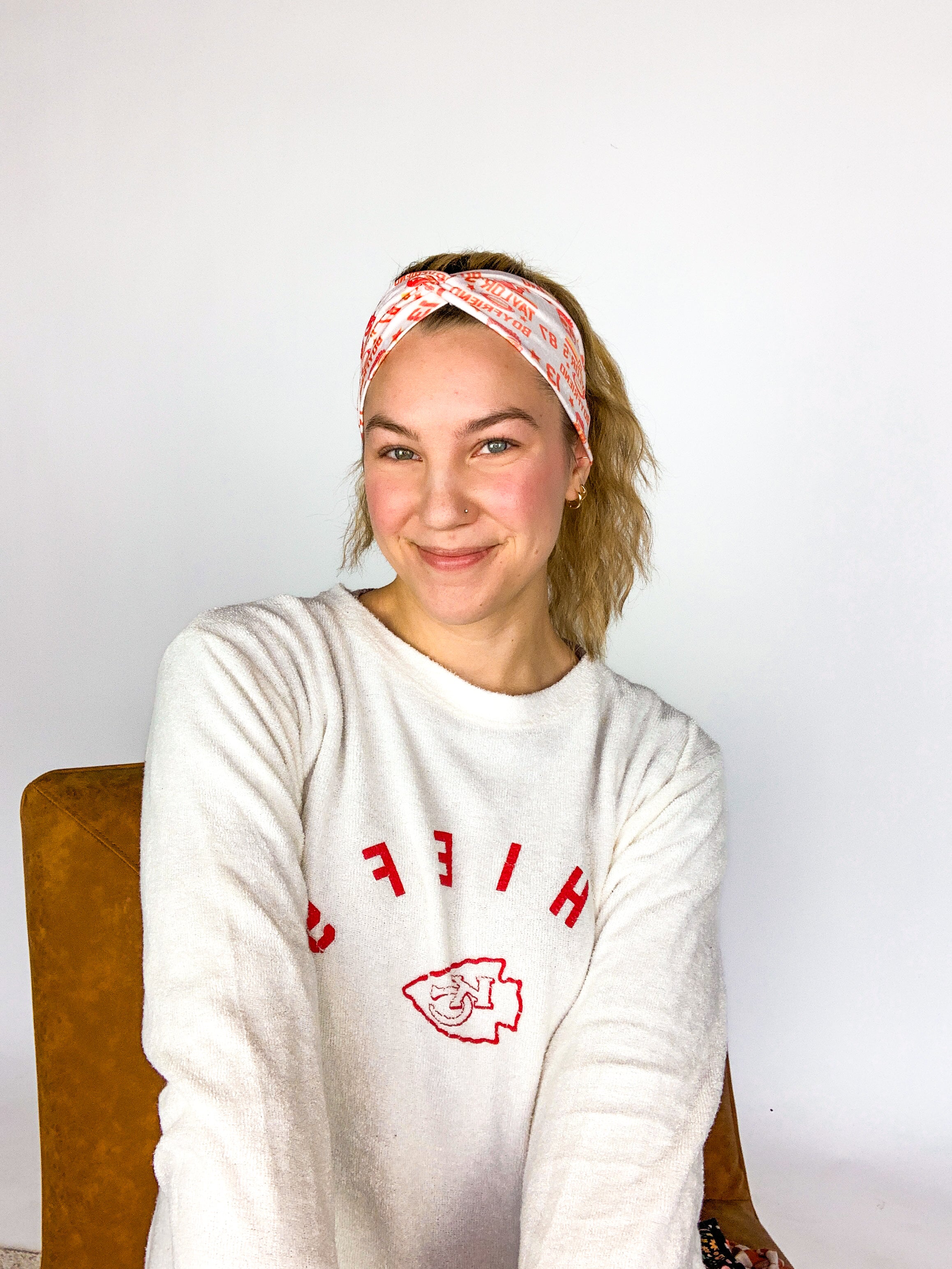 Adult women's grey headband with red and yellow drawings of Travis Kelce, his jersey number, KC Chiefs and hand-drawn hearts that says 'Go Taylor Swift's Boyfriend'