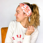 Adult women's grey headband with red and yellow drawings of Travis Kelce, his jersey number, KC Chiefs and hand-drawn hearts that says 'Go Taylor Swift's Boyfriend'